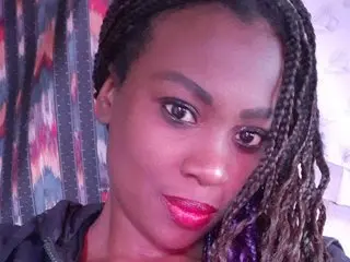 Naughtyyblack poses for a close-up selfie with her braided hair and red lipstick.