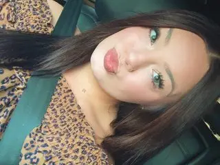 Nicolew123 with long dark hair wearing a leopard print top sitting in a car seat with a seatbelt on.
