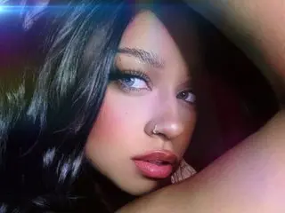 NoahBensi looks directly at the camera with long dark hair and a close-up view of her face and shoulders.