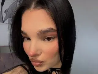 Noirbeauty poses close up, showing her dark hair and face with a soft, direct gaze.