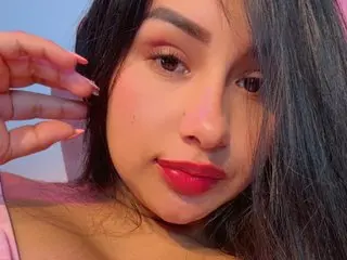 PrettyDaniels poses close-up, showing her face, dark hair, and red lipstick against a plain background.