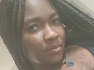 PrettyTings looks directly at the camera with her dark hair in long braids.