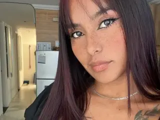 Reislin_69 shows off her long dark hair and clear skin in a close-up selfie, wearing a silver chain necklace.