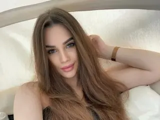 RiverVigro poses with her long brown hair flowing over her shoulders, looking directly at the camera with a soft expression.