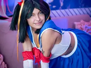 SakuraTao poses in a blue and white sailor-style outfit, showing her cleavage and shoulders with her black hair styled in a bob.