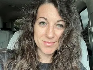 Sammie_Ray shows her face and long, wavy brown hair while looking directly at the camera in a close-up shot.