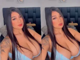 Samy_Thomas poses with long dark hair, wearing a light blue bra that shows off her large breasts and cleavage.