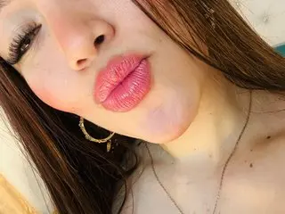 SashaDurante looks into the camera with pink lipstick and long dark hair in a close-up selfie.