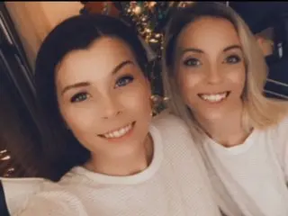 Scarlett_And_LucyMae posing together, showing their faces and shoulders while wearing white tops.