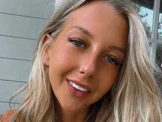 Scarlettt_21xxx smiles while looking directly at the camera with her long blonde hair framing her face.