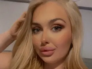 ScottishxChiara poses with her blonde hair swept back, looking directly at the camera with a soft expression.
