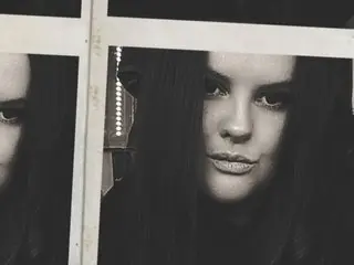 SecretDestinyyxx looks into the camera with a serious expression in this black and white close-up shot.