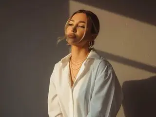 SecretVanilla poses in a white button-down shirt with her eyes closed under warm sunlight.