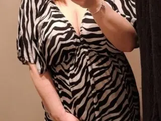Secret_Skye_XO wears a black and white zebra print top with a deep V-neckline while posing for a selfie.