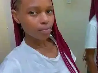 Sexybitchh22 poses with her long red hair down, wearing a white t-shirt against a plain wall background.