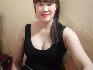Sexygirl33x — Smiling woman in a black tank top sitting indoors with a warm, casual mood.