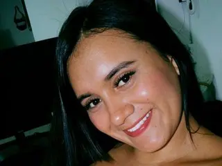 SharomLess47 smiling at the camera with long dark hair in a close-up selfie.