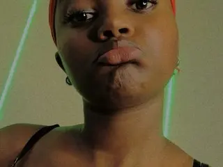 Shidydy looks directly at the camera with a pouty expression, showing her face and shoulders against a plain background.