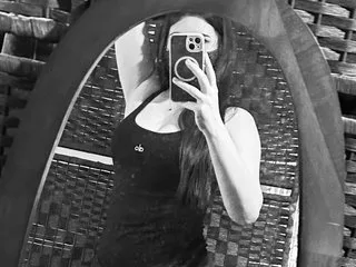 Sillytilly20 takes a black and white mirror selfie wearing a tight black tank top.
