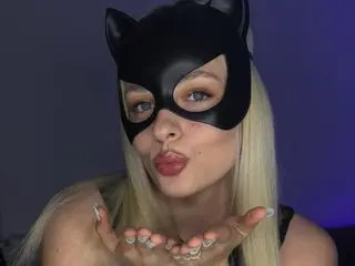 SinnerEva wearing a black cat mask, blowing a kiss with her blonde hair down and hands held near her face.