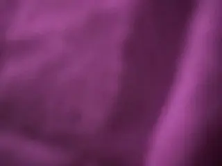 Slimthickdesi shows her bare skin and body in a close-up shot with a purple hue.