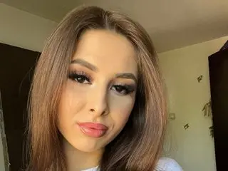 SophieEloise poses close-up, showing her face and long brown hair with a soft, direct gaze.