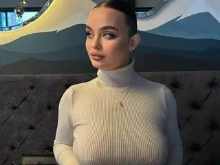 StarStormy poses in a white turtleneck, showing her dark hair pulled back and her face looking directly at the camera.