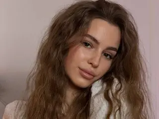 StellaHoneywell poses with her long, wavy brown hair down, looking directly at the camera in a close-up shot.