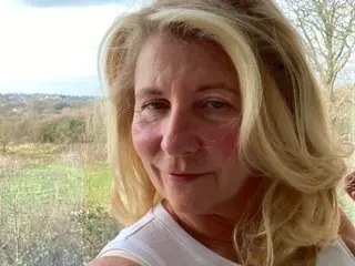 SundayGirl smiles while looking directly at the camera with her blonde hair framing her face.