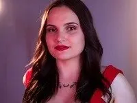 Sweet_Boobssss poses with long dark hair and red lipstick, wearing a red top against a plain background.