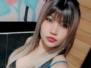 Sweetwhisper24 looks at the camera with long brown hair and red lipstick while wearing a black top.