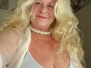 THESensualhorny poses with her long blonde hair, wearing a white top and a white pearl necklace.