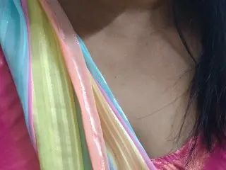 TamilAlazhi shows her bare chest and neck, wearing a pink and yellow silk garment that drapes over her shoulder.