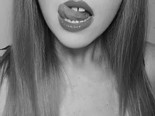 Close-up black and white portrait of a playful young woman with long hair sticking her tongue out.