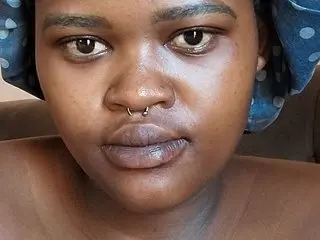ThickPearlx23 looks directly at the camera with a close-up headshot, wearing a blue polka-dot headwrap or hat.