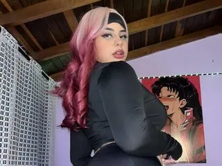 Tokyoseis poses in a black long-sleeve top, showing her pink and black hair and dark eyes against a simple indoor background.