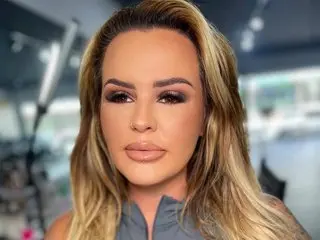 Toxxiccangel poses with a close-up headshot, showing her long blonde hair and heavy eye makeup.