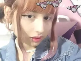 Tsumugi looks at the camera with a direct gaze, showing her face, light brown hair, and a small silver nose ring while wearing a denim shirt.