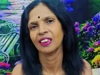 Vanny4Luv — Smiling Indian woman with long black hair and bindi posing against a colorful floral garden background.