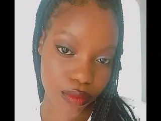 VeneusGoddessxoxo looks into the camera with dark hair in braids and red lipstick.