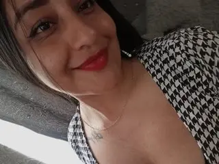 Venuz88 smiles while wearing a black and white houndstooth top that shows off her cleavage and neck.