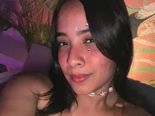Violehtt poses with a direct gaze, showing her face, dark hair, and neck, wearing a delicate white beaded necklace.