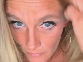 Vixxendoll87 poses with her blonde hair framing her face, looking directly at the camera with a close-up view of her eyes and facial features.