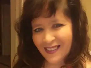 Vondi smiles while looking at the camera, showing her long dark hair and face in a close-up shot.