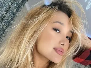 Webcamgril poses with her long blonde hair framing her face, looking directly at the camera with a soft pout.