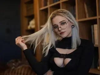 Xinsea poses with her long blonde hair and a black turtleneck top that features a deep cutout showing her cleavage.