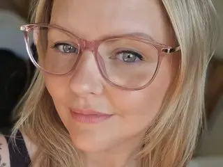 Xo_SweetCherryPie_oX poses for a close-up selfie, showing her blonde hair and face behind clear-rimmed glasses.