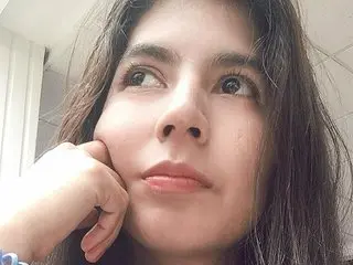 Zharid_Parker looks up with a thoughtful expression, resting her chin on her hand.