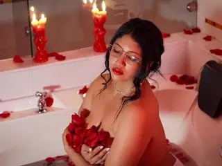 Romantic woman with red roses in a candlelit bathtub surrounded by rose petals for a moody Valentine's aesthetic.