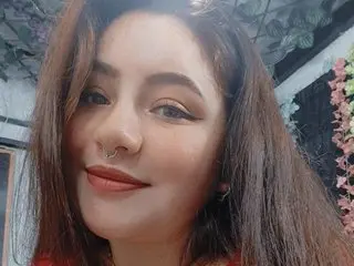 annbronw smiling for a close-up selfie with long brown hair and a nose ring.